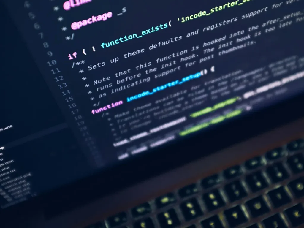 Website code on a laptop screen in a dark room