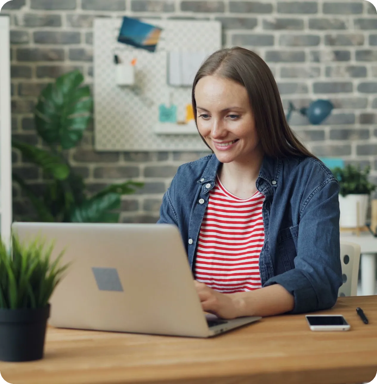 Smiling business owner working on a laptop in a bright office